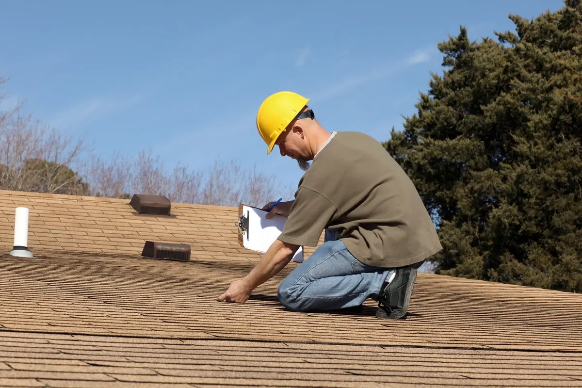 The Importance of Roof Inspection: home inspector checking a homeowner’s roof